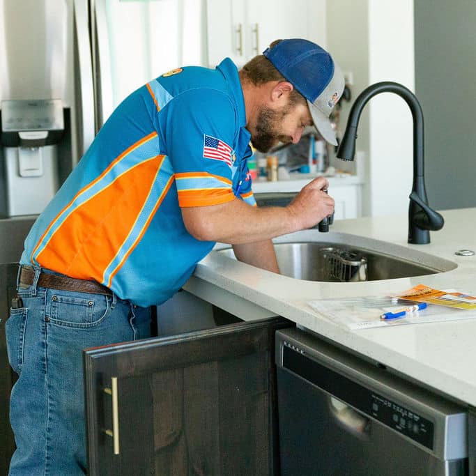 Plumber installing a kitchen sink