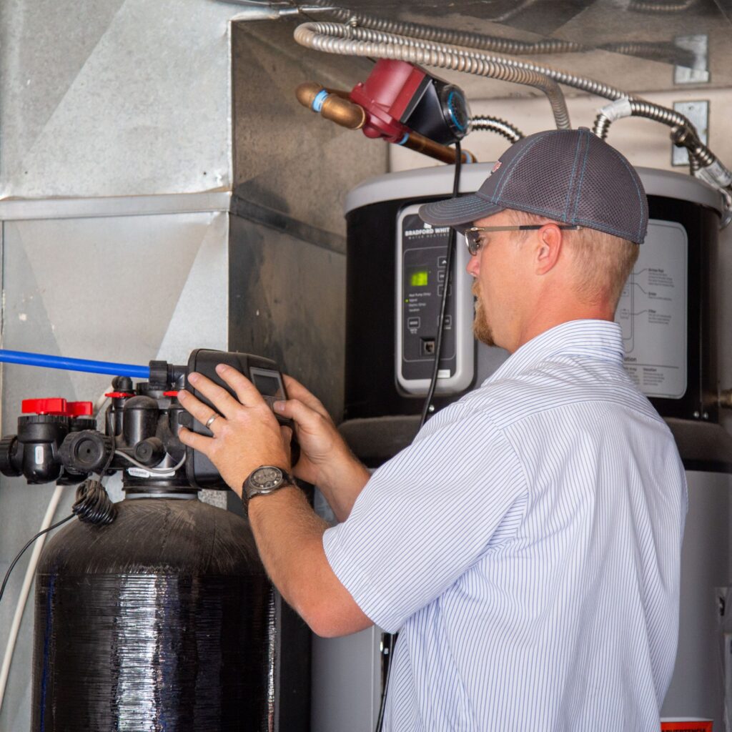 Plumber installs water softener.