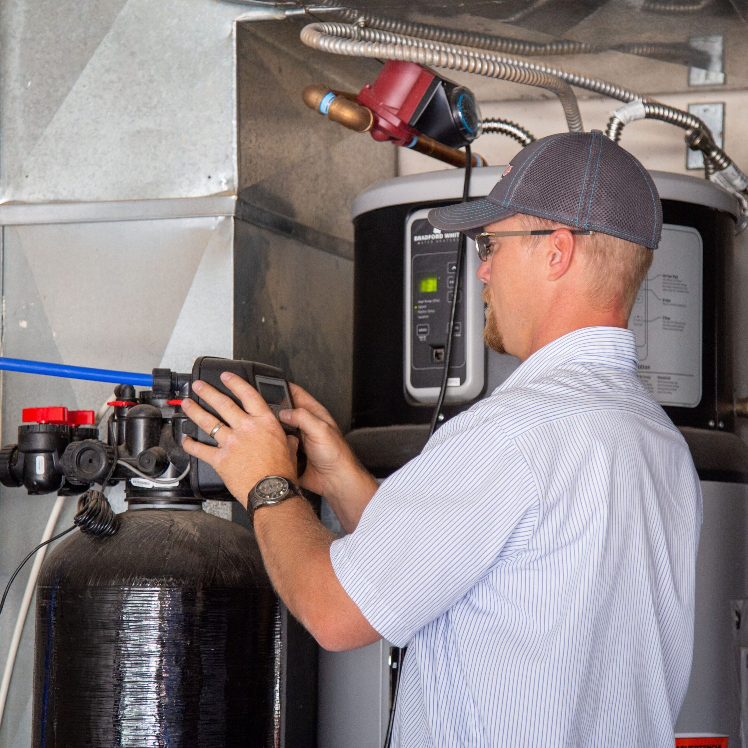 Plumber installs water softener.